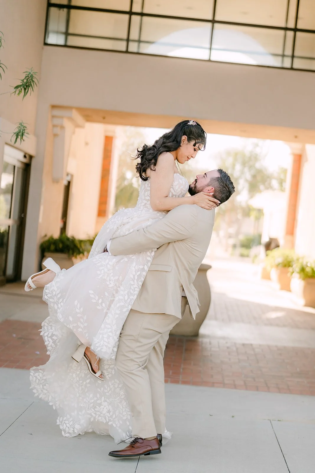 Cody lifting Fernanda in front of an arched entry.