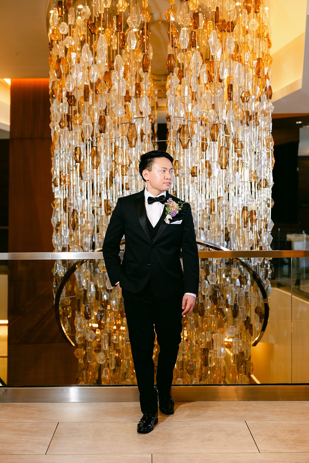 Hoan in his tuxedo standing before the lobby's sculptural amber installation