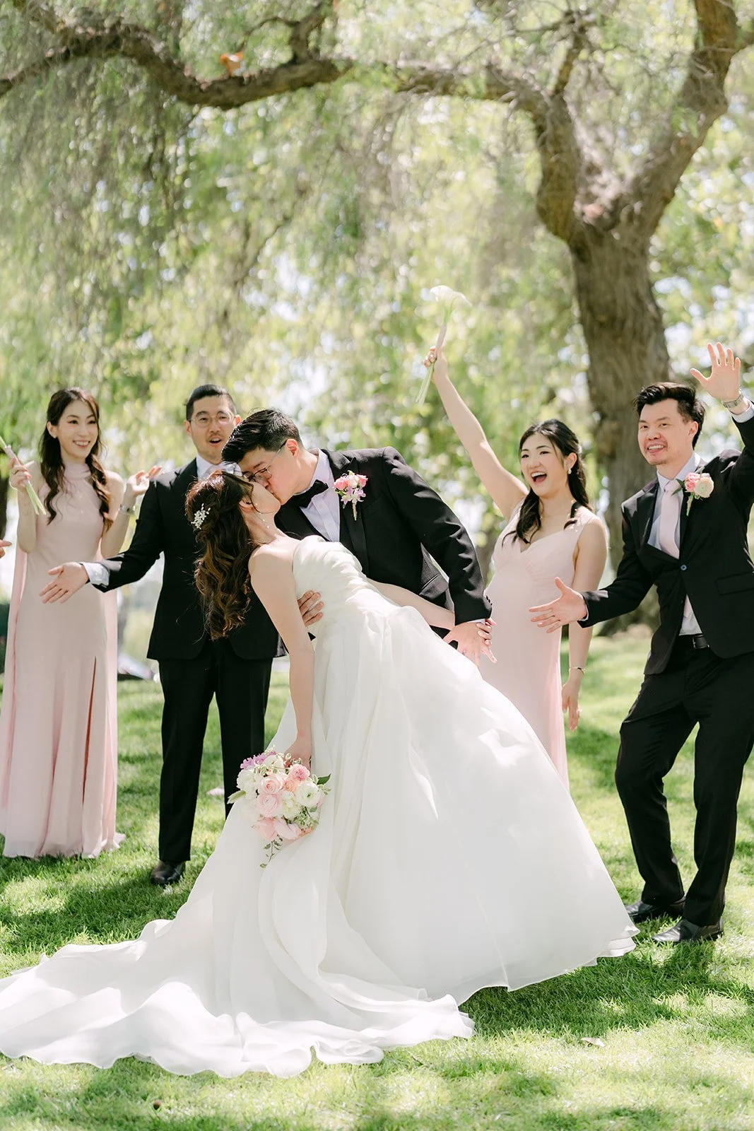 The wedding party cheering on the lawn
