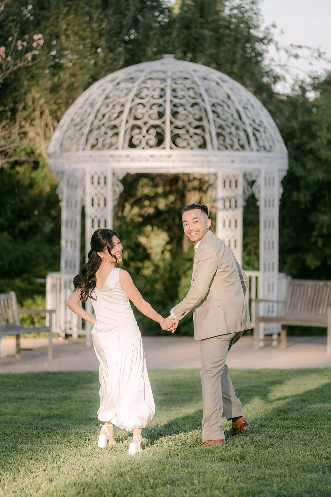 Kim and Vincent holding hands in front of the white gazebo.