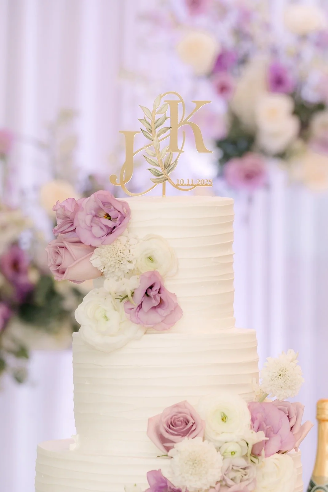 Lavender and blush roses tucked into the tiers of the wedding cake