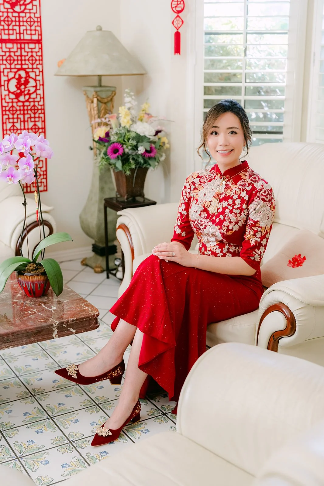 Pauline seated beside red couplets.