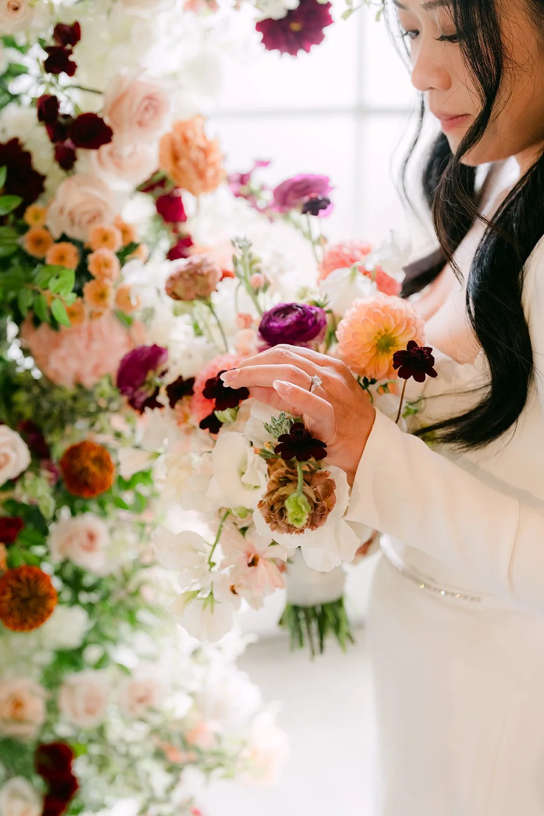 Denise touching the peach and burgundy flowers on the floral columns.