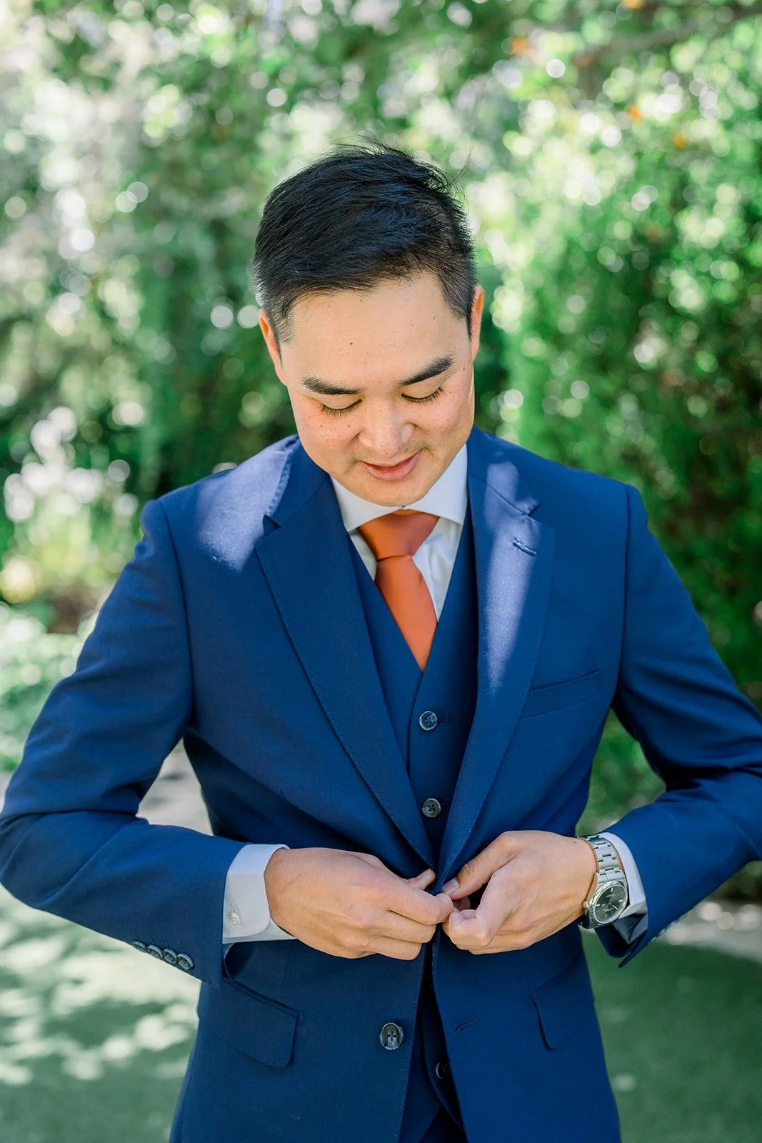 Vincent buttoning his navy three piece suit