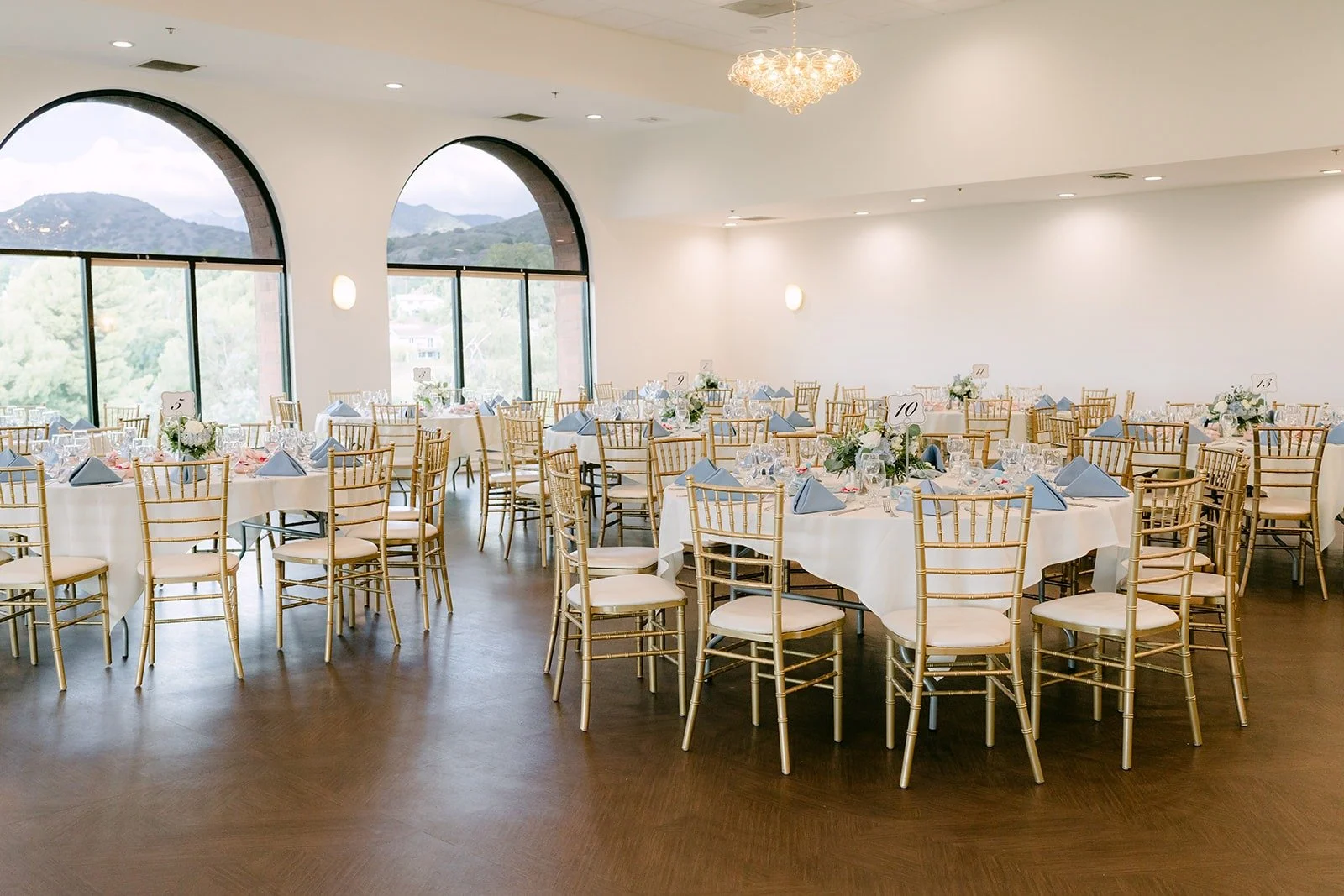 The reception room at Sierra La Verne set with gold chairs and white linens