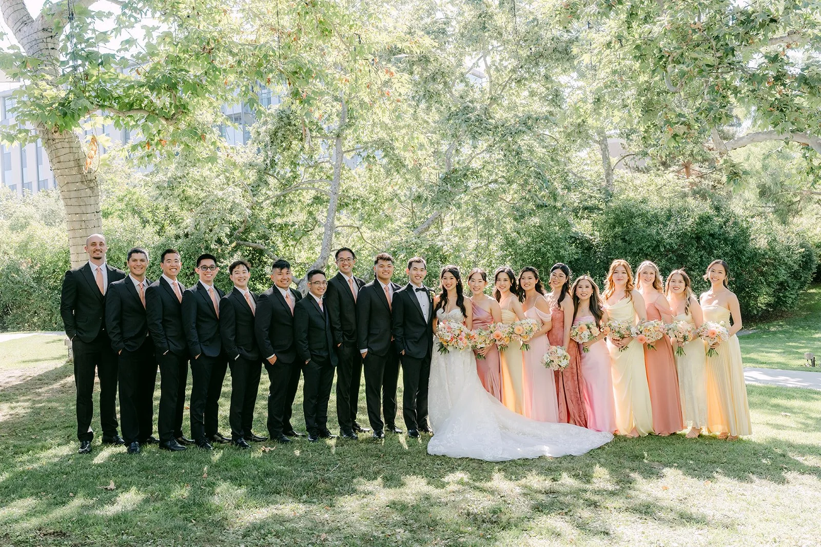The full wedding party lined up under the trees at the University Club