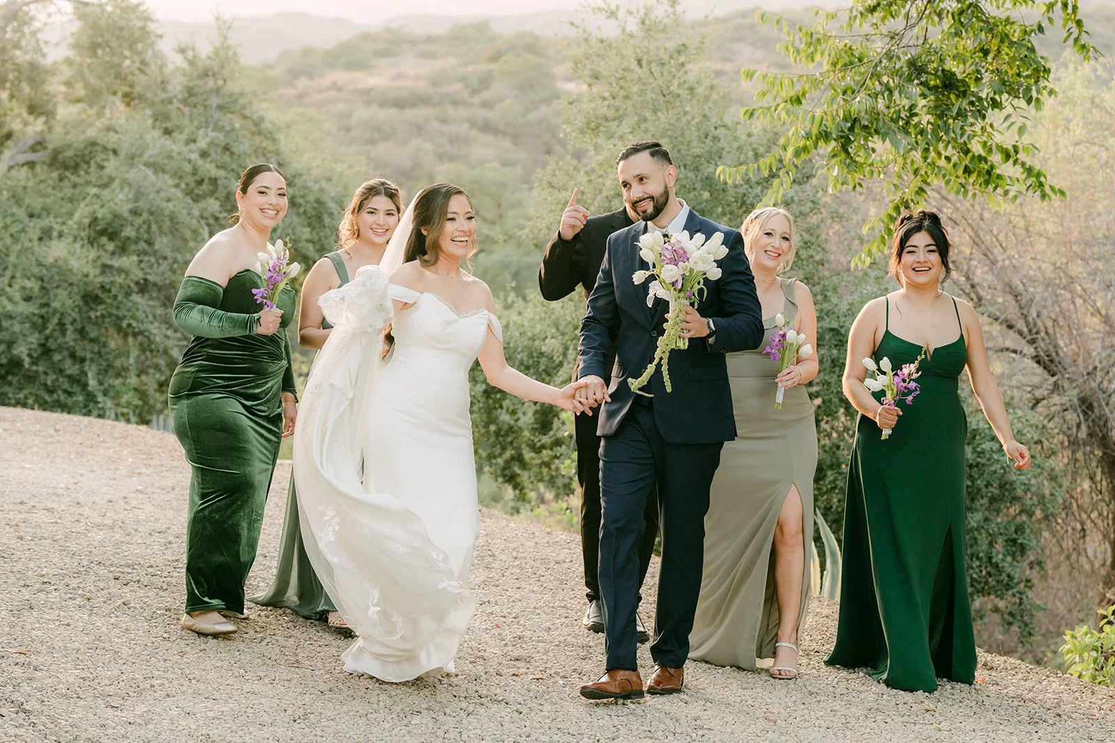 Mariana and Danny walking toward the camera with their wedding party