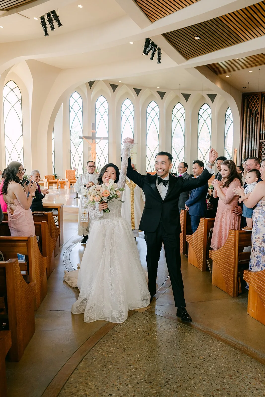Kim and Vincent cheering as newlyweds down the aisle