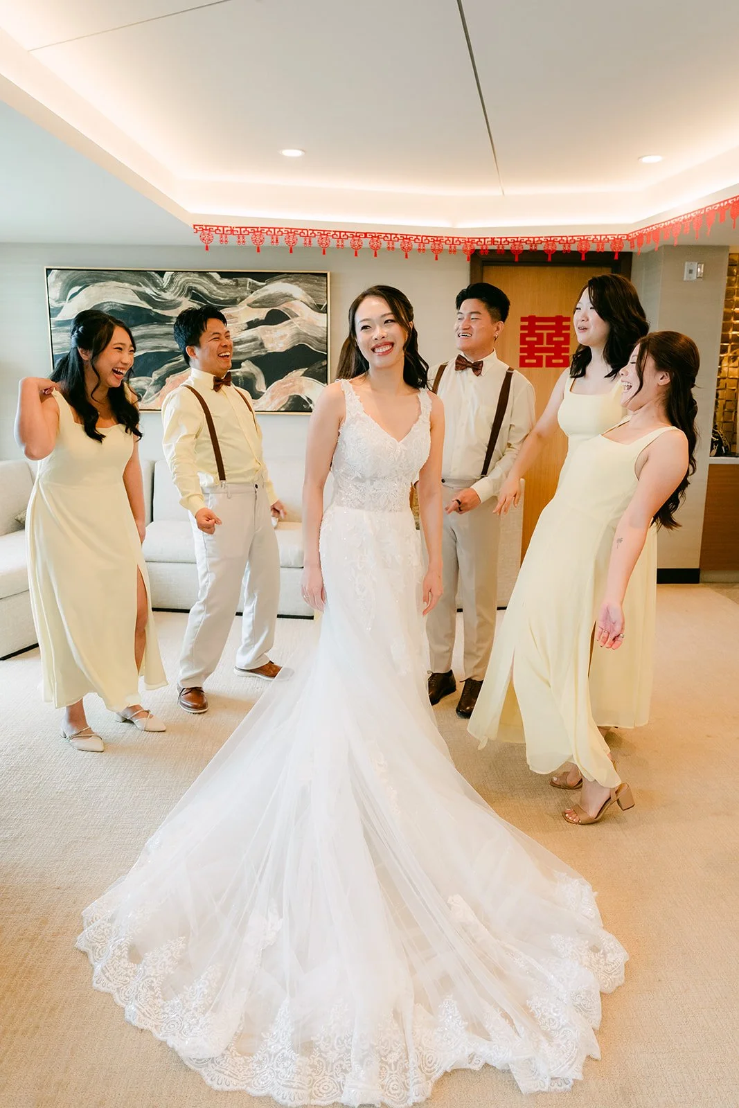 Jenny's long train spread across the floor as her bridesmaids celebrate.