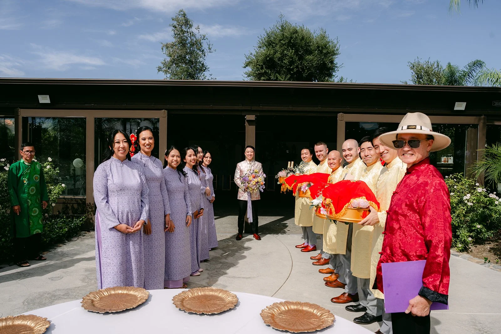 Bridesmaids in lavender ao dai receiving gift trays from the groom's procession.