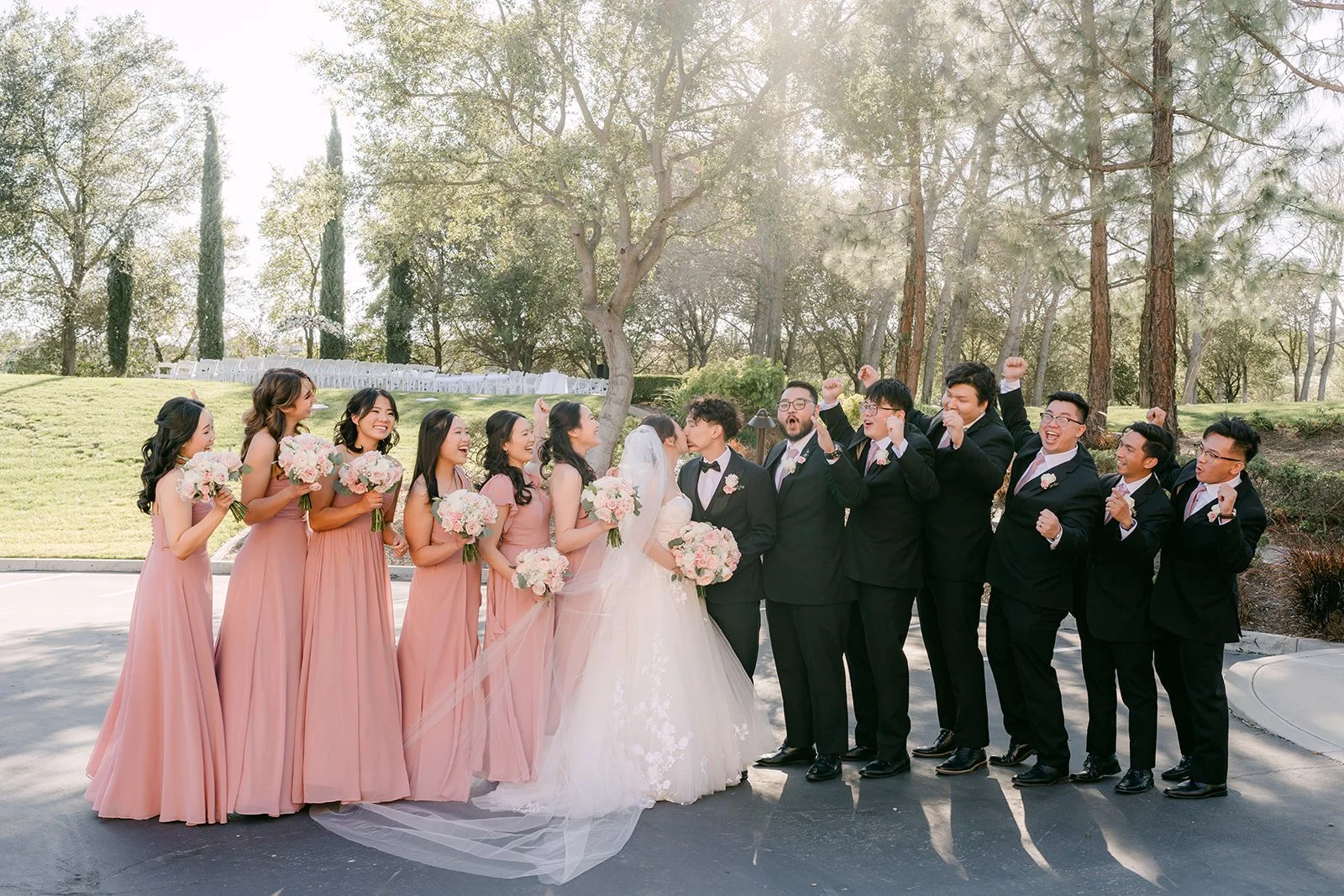 Wedding party laughing together under the trees