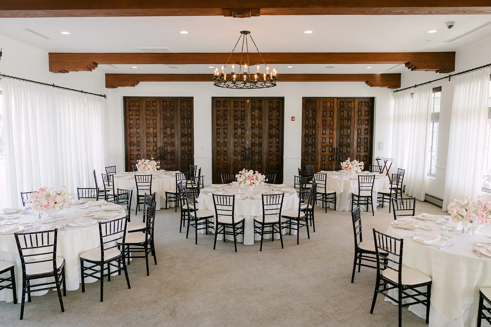 Reception tables with blush centerpieces and black chiavari chairs