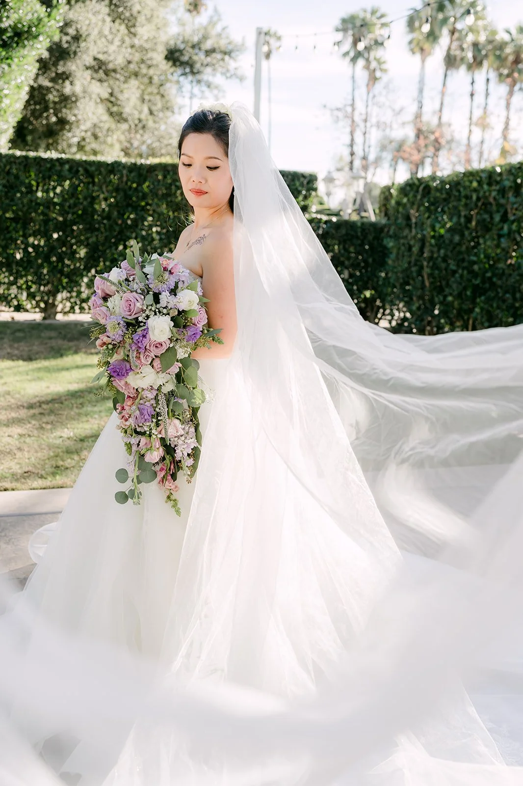 Kate's veil sweeping behind her as she holds her bouquet.