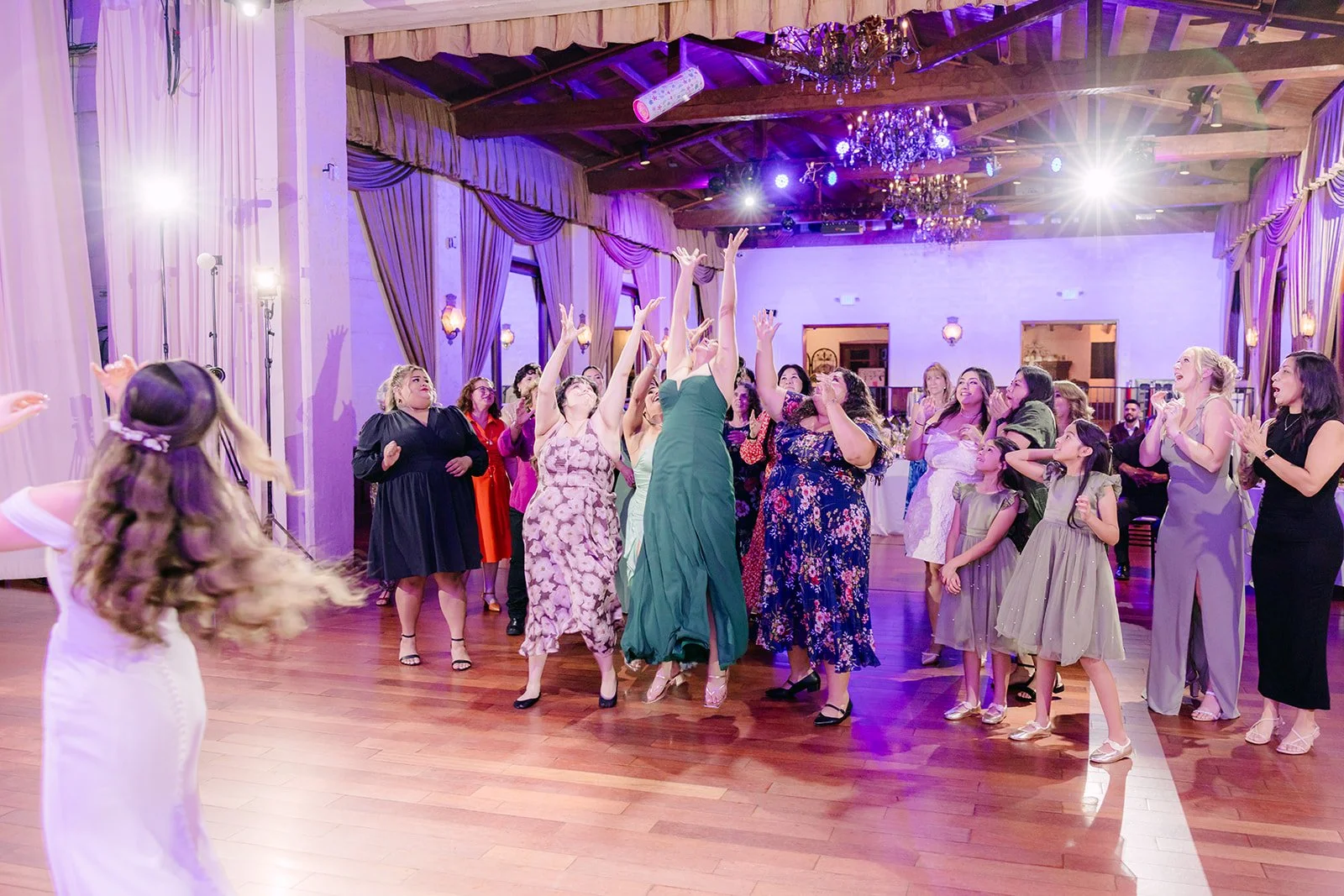 Guests reaching for the toss on the dance floor