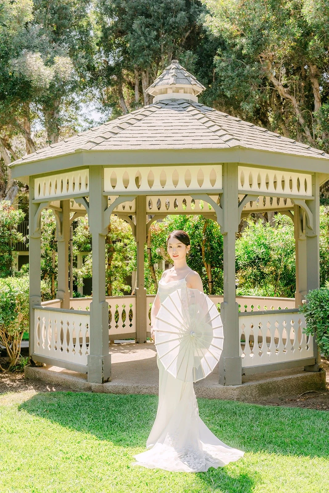 Tin with her veil spread wide in front of the gazebo, photographed by One and Only Production