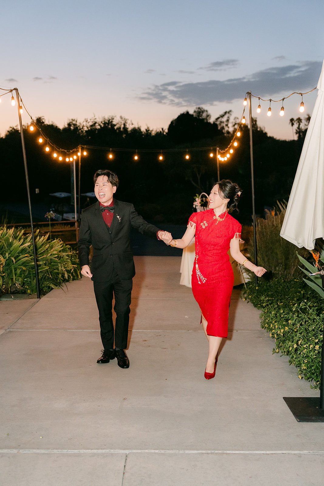 Elaine and Wen dancing into the reception under the string lights.