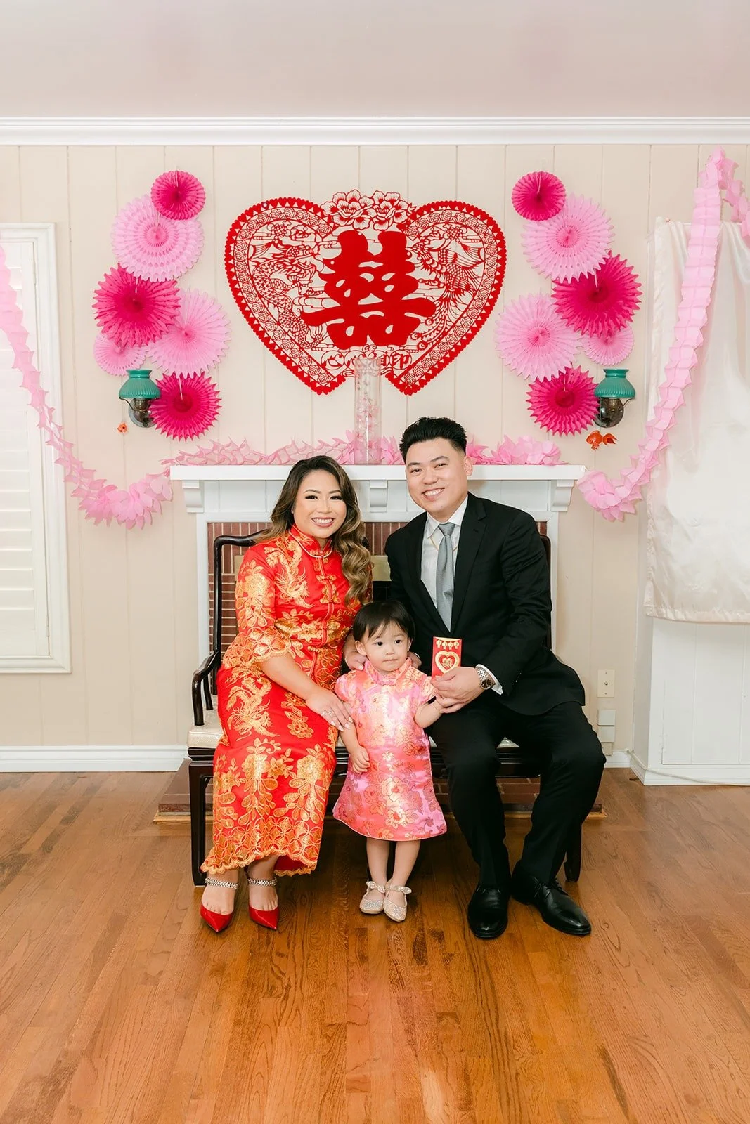 Candice and Vincent seated in front of the double happiness backdrop