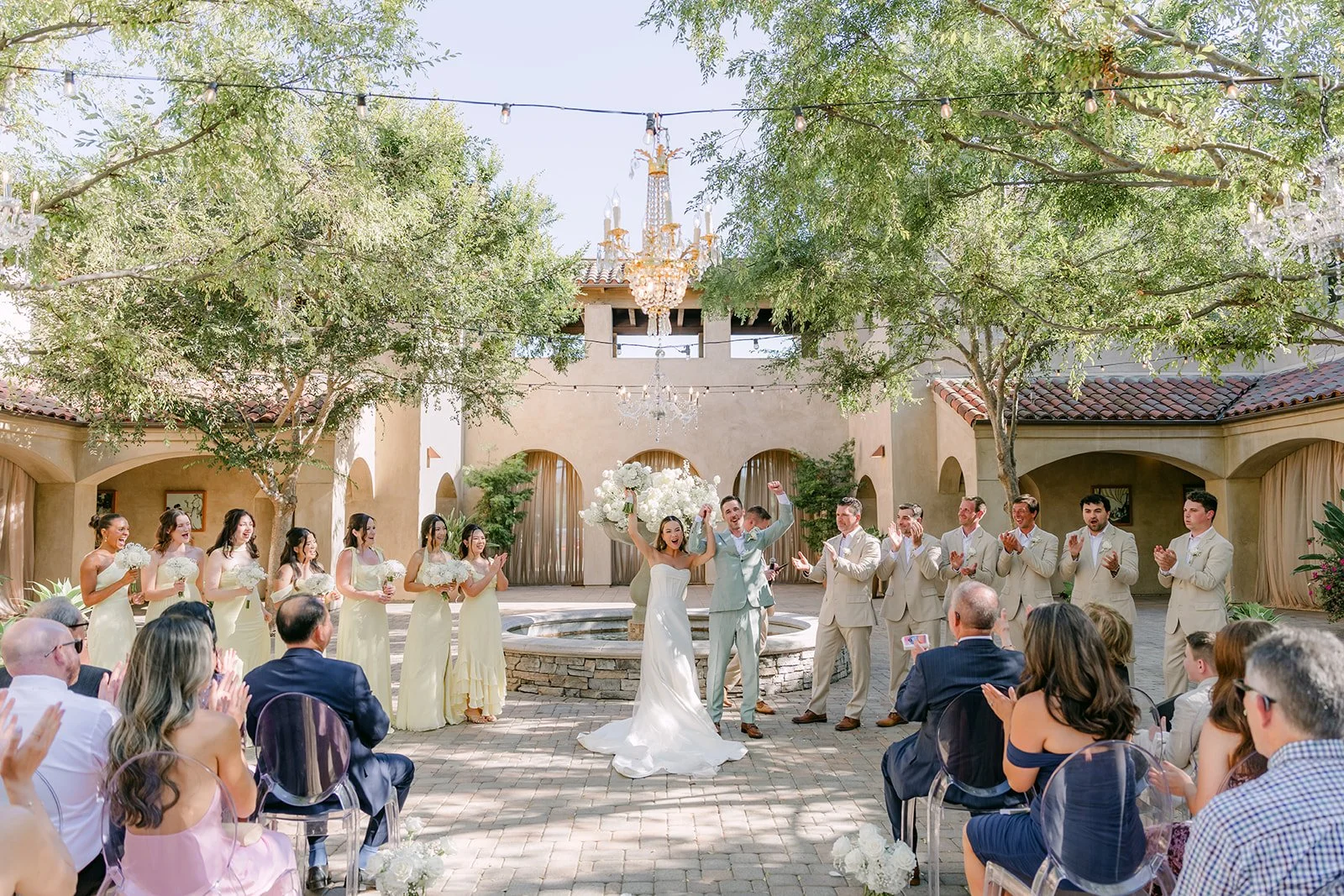 Wide view of the courtyard ceremony with the wedding party around the fountain