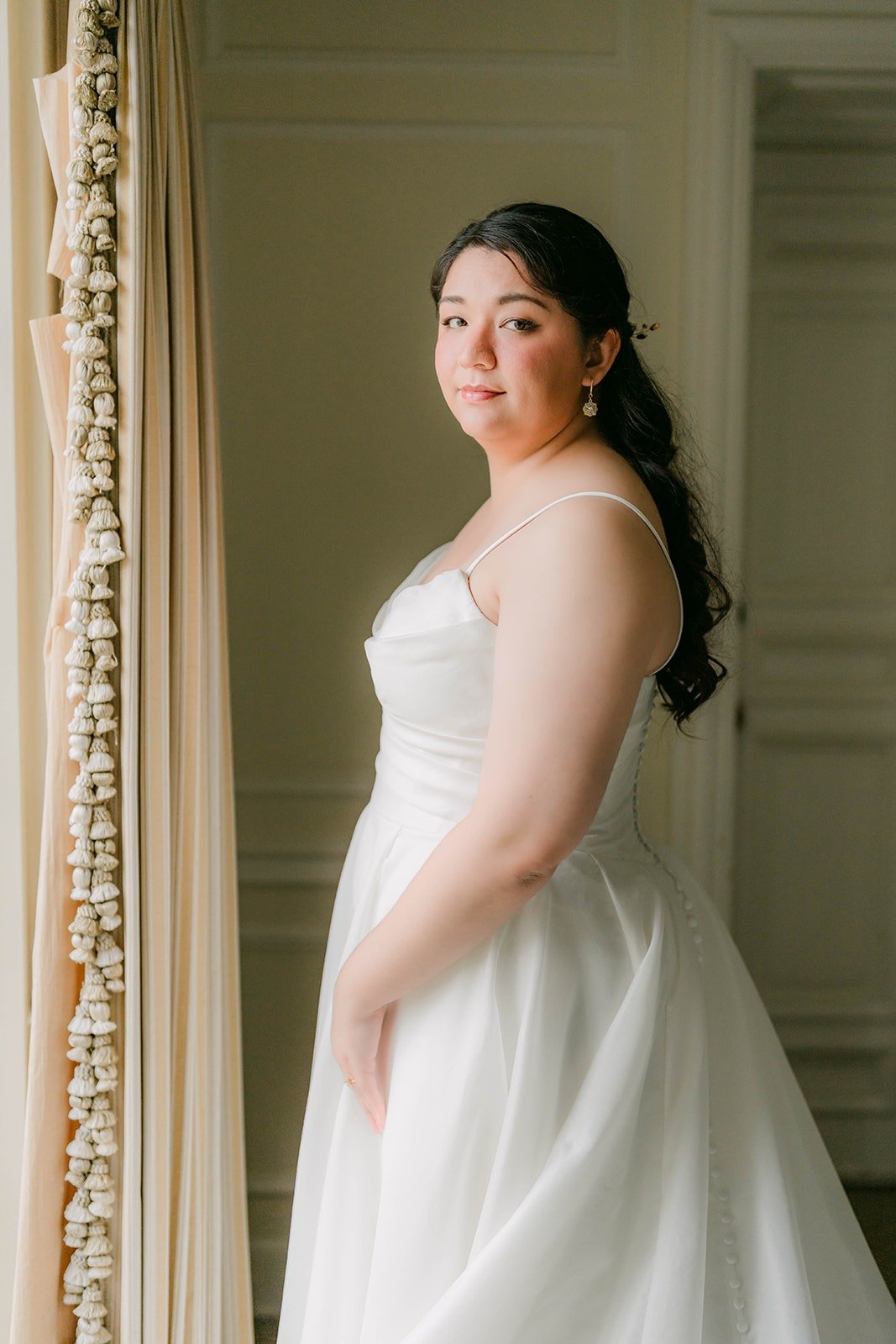 Saira in her wedding dress looking over her shoulder in the bridal suite