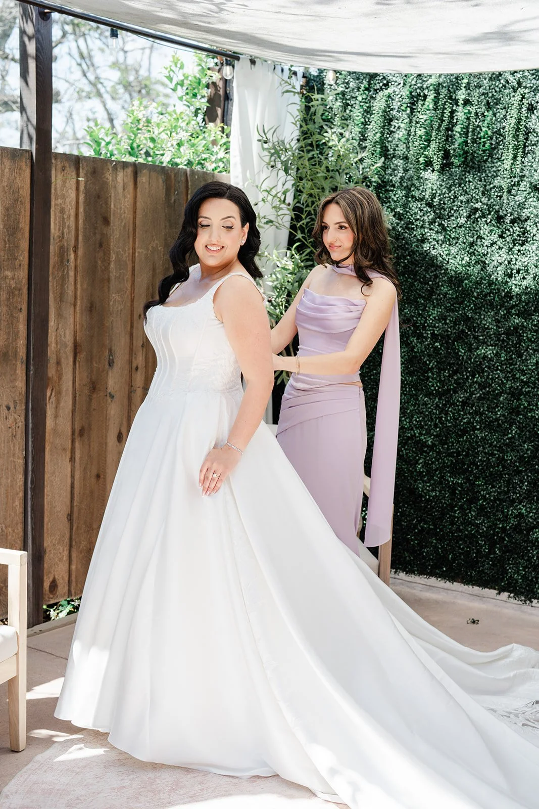Mother of the bride buttoning Mariam's gown