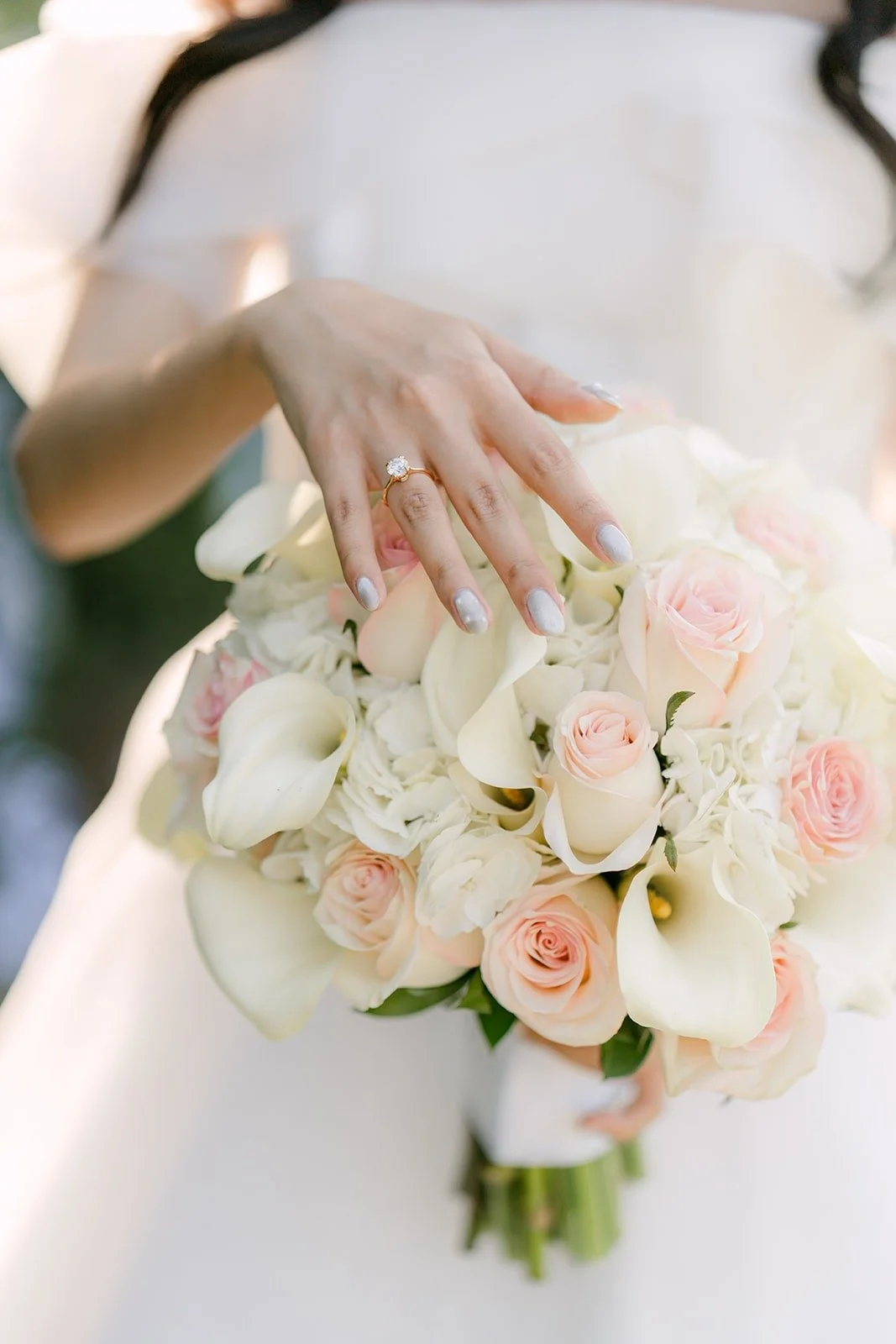 Close up of Jeannie's ring and her blush and ivory rose bouquet