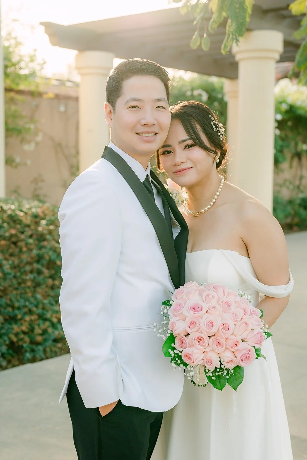 Ivy resting her head on Chungman's shoulder with her pink rose bouquet