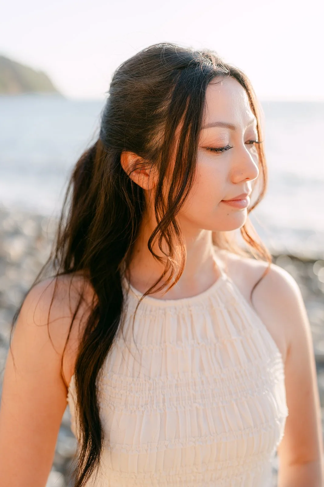 Portrait of Victoria with her hair blowing in the sea air.