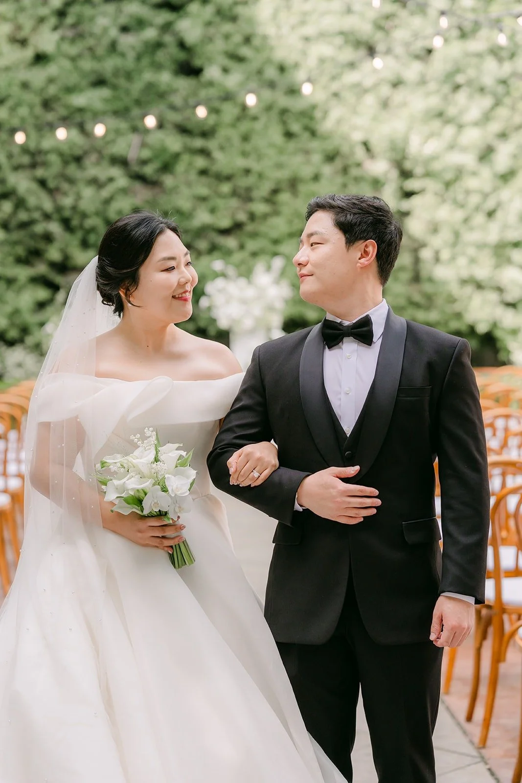 Chorok holding Min Soo's arm in the ceremony aisle at Franciscan Gardens