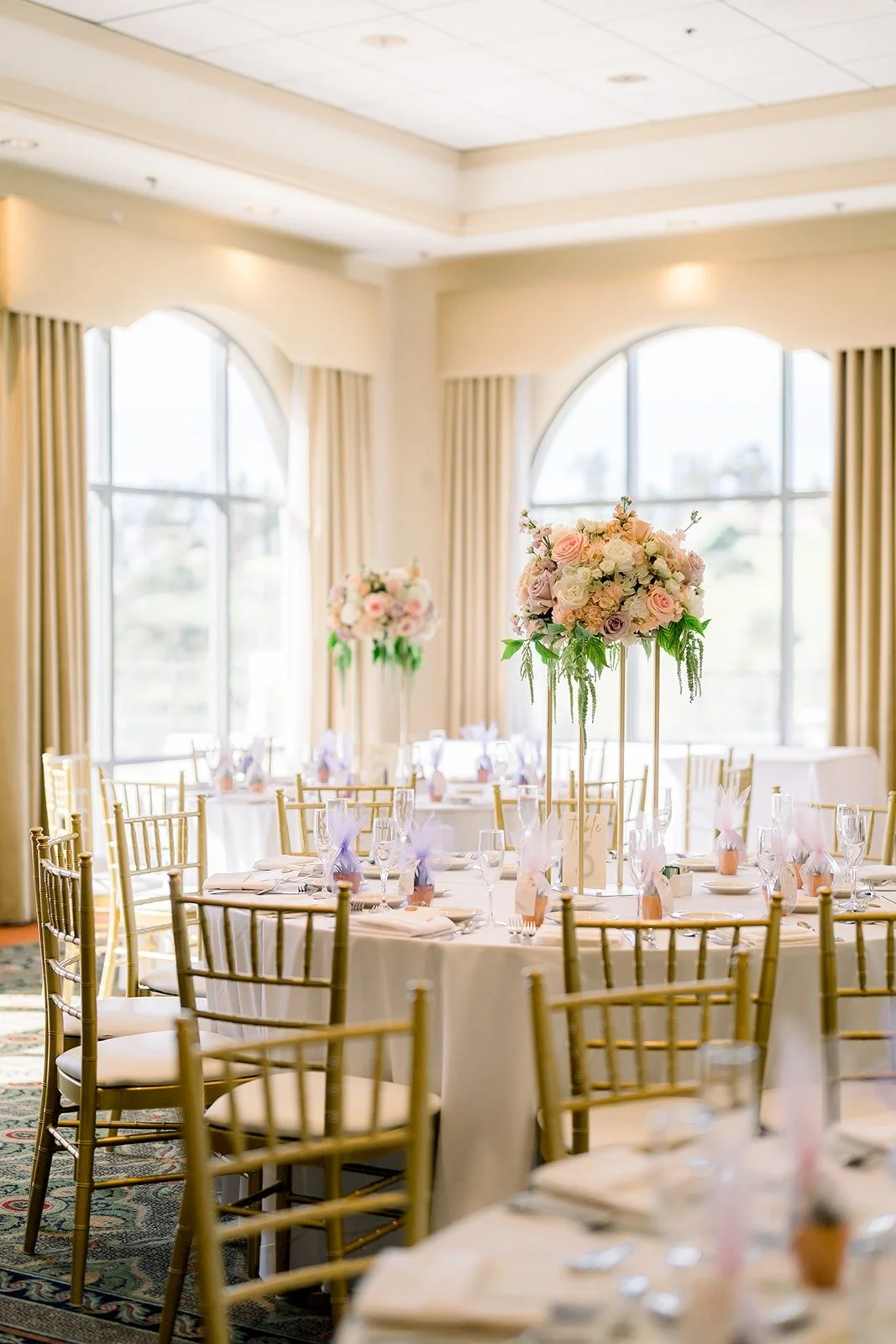 The reception room at The Clubhouse at Anaheim Hills set with gold chairs and blush centerpieces