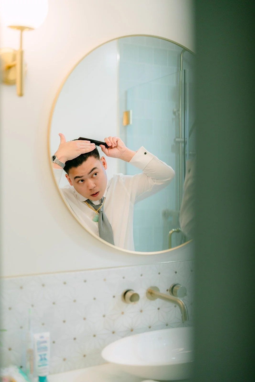 Vincent fixing his hair in the mirror