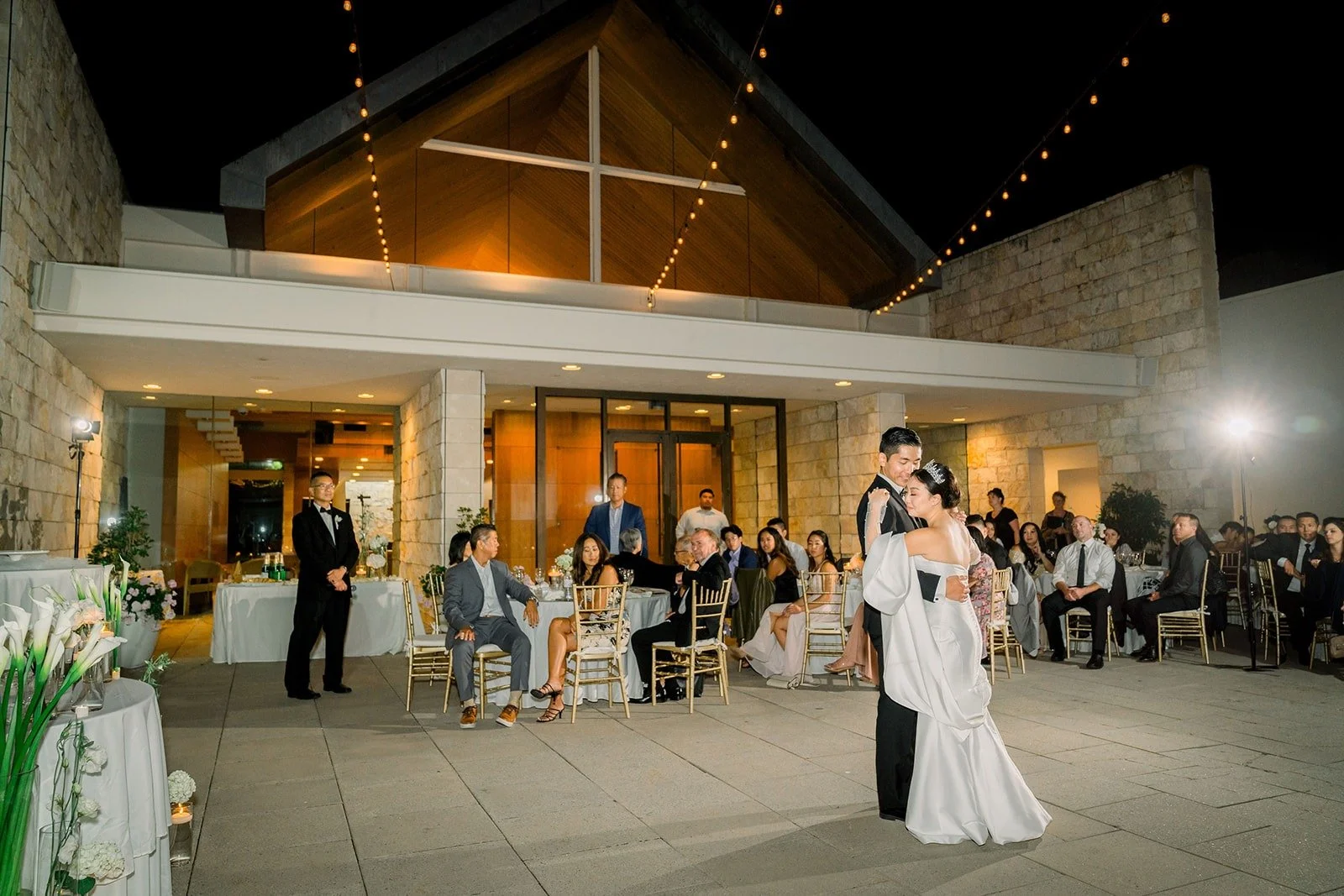 Wide view of the patio at night with the church lit up behind the dance, photographed by One and Only Production