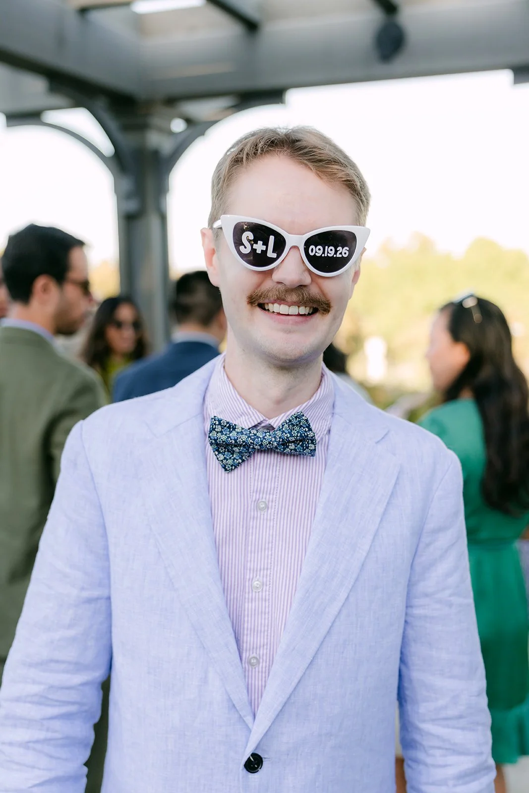 A guest in custom wedding sunglasses and a bow tie