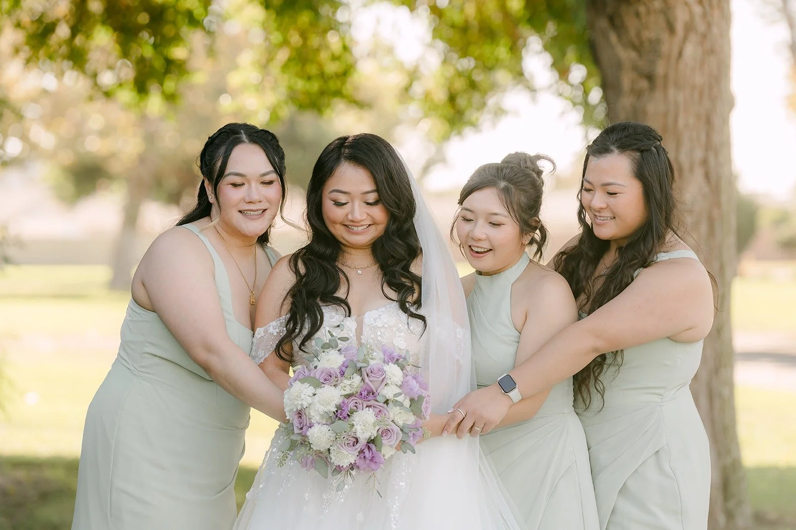 Jennifer and her bridesmaids lean in around her bouquet