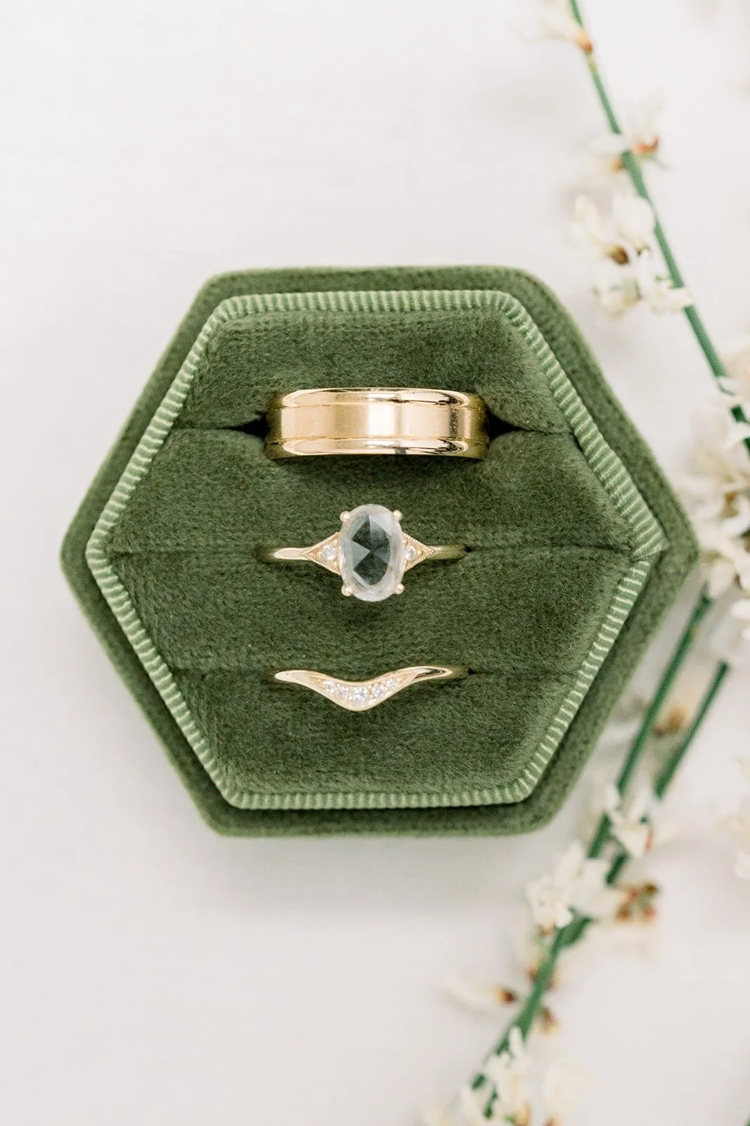 Wedding bands and engagement ring in a green velvet hexagon box