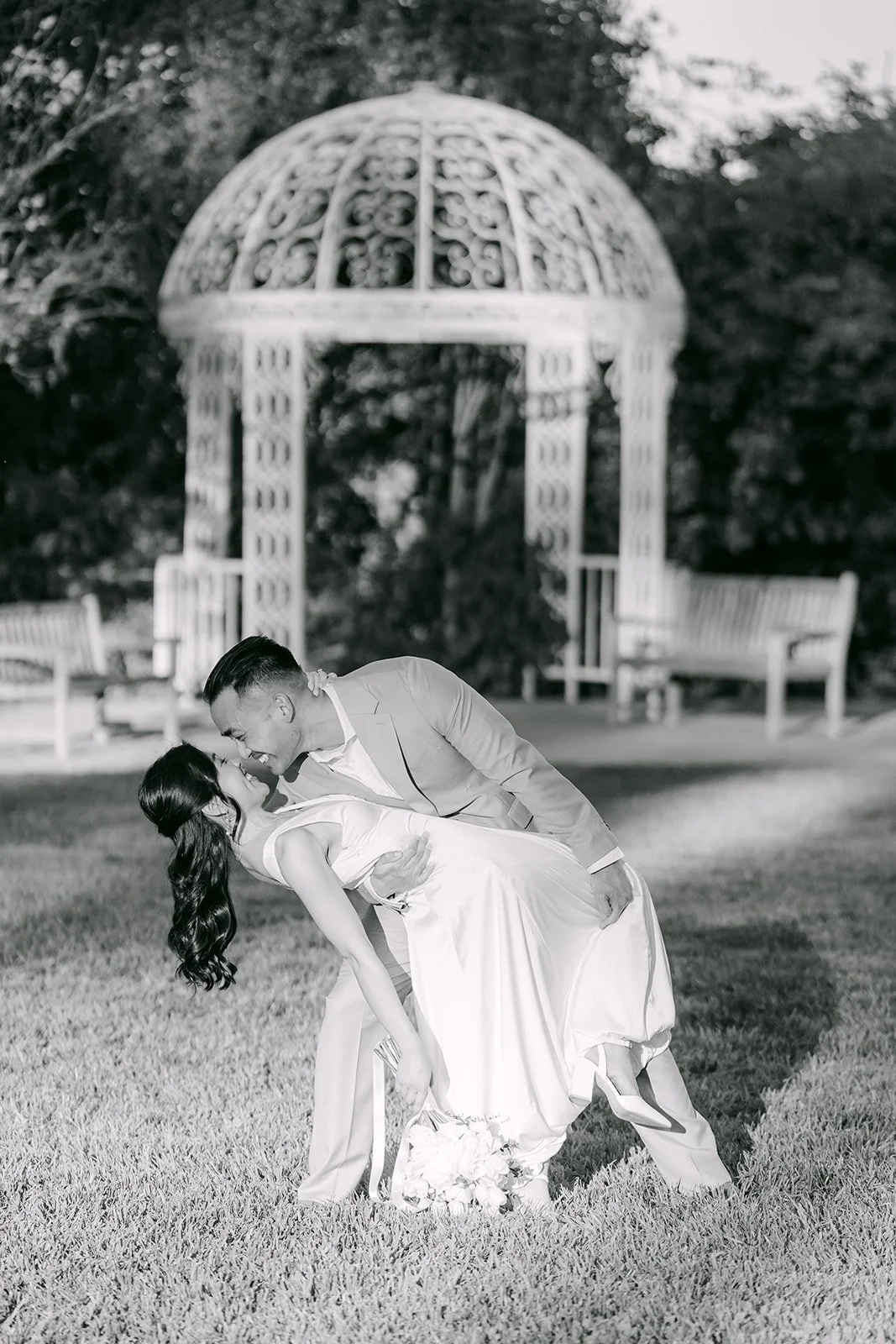 Black and white dip kiss in front of the white gazebo.
