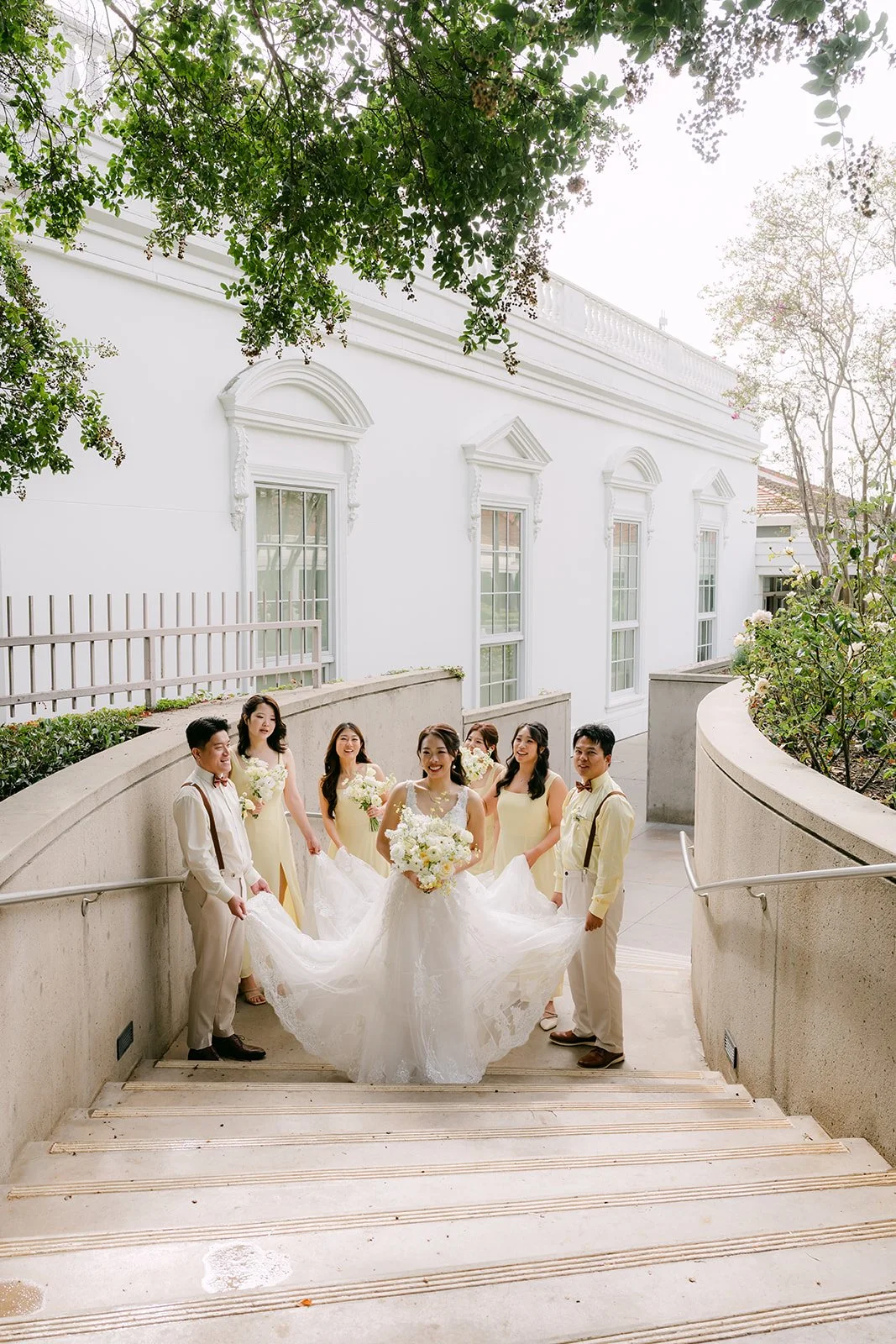 Jenny's gown spread across the steps with her bridesmaids around her.