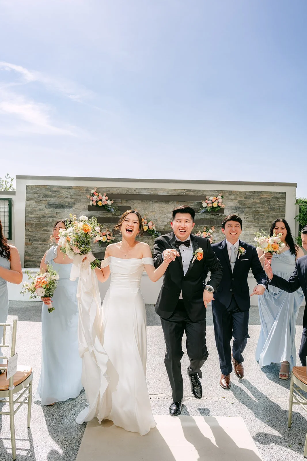 Amanda and San walking with their wedding party at Courtyard Monterey Park, photographed by One and Only Production.