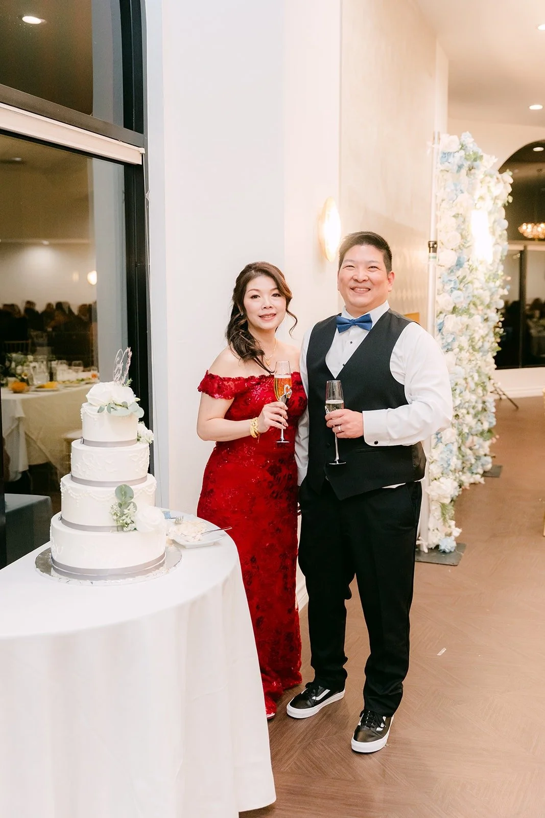 Sochi and Jay toast with champagne by the cake, photographed by One and Only Production
