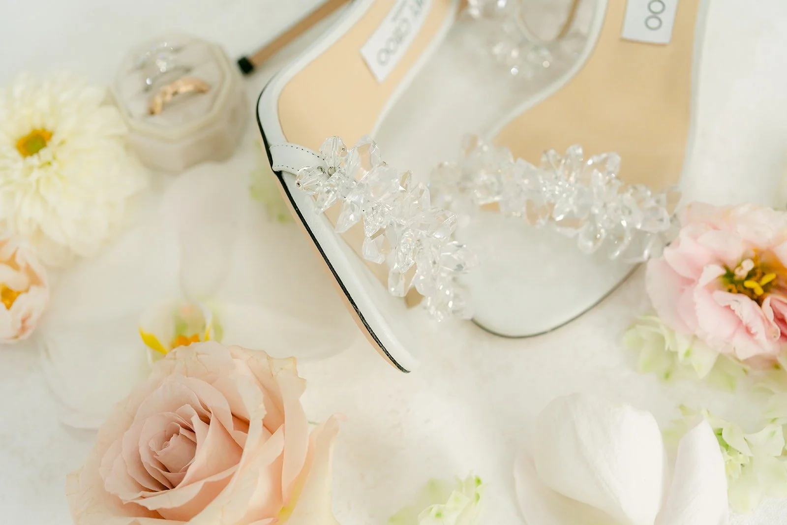 Sparkling wedding heels laid out with roses