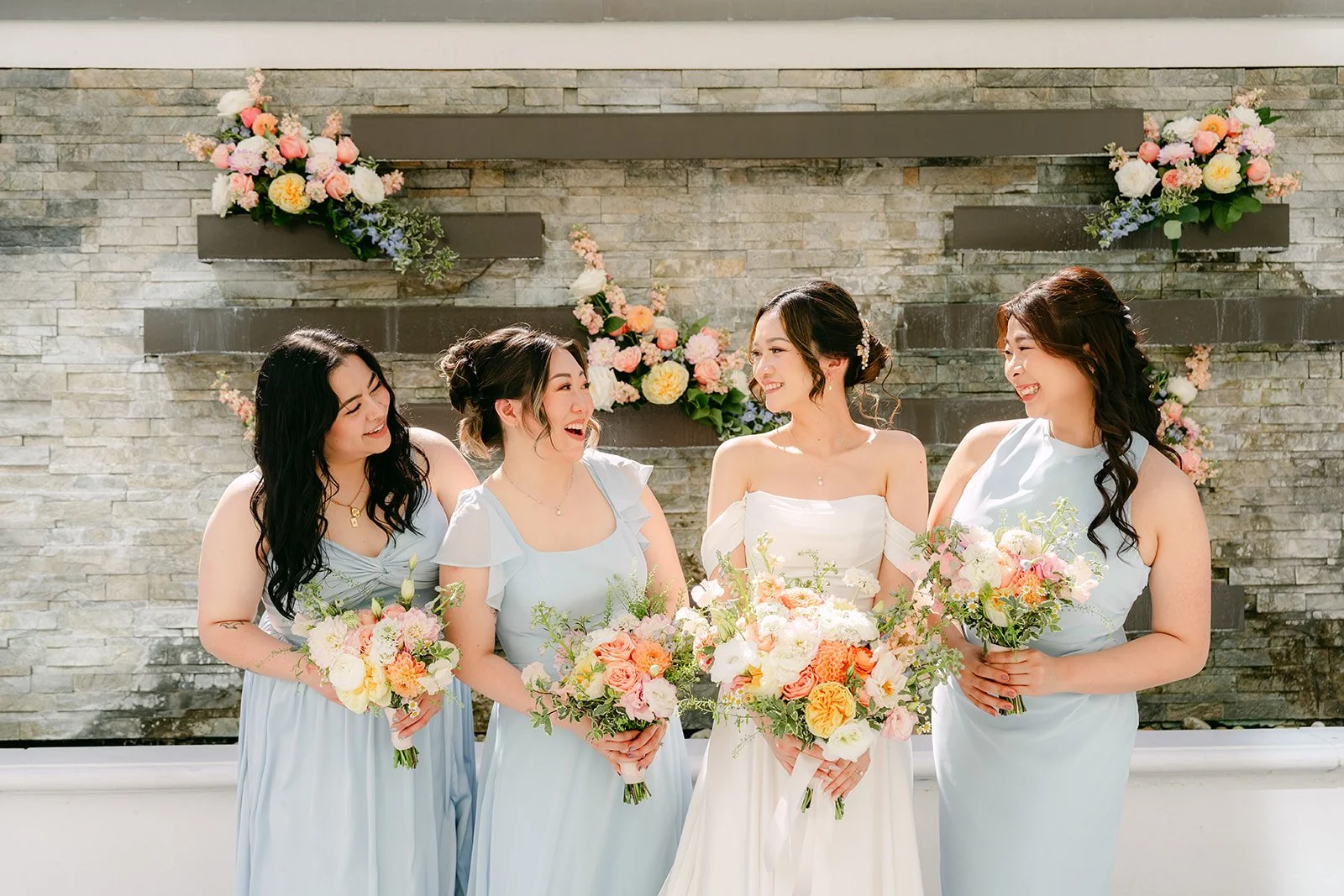 Amanda's bridesmaids holding their pastel bouquets in a row.
