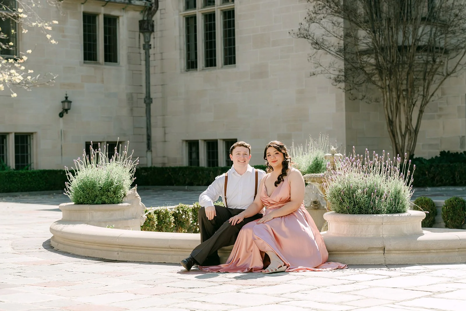 Saira and Matthew seated at the motor court fountain in front of the mansion.