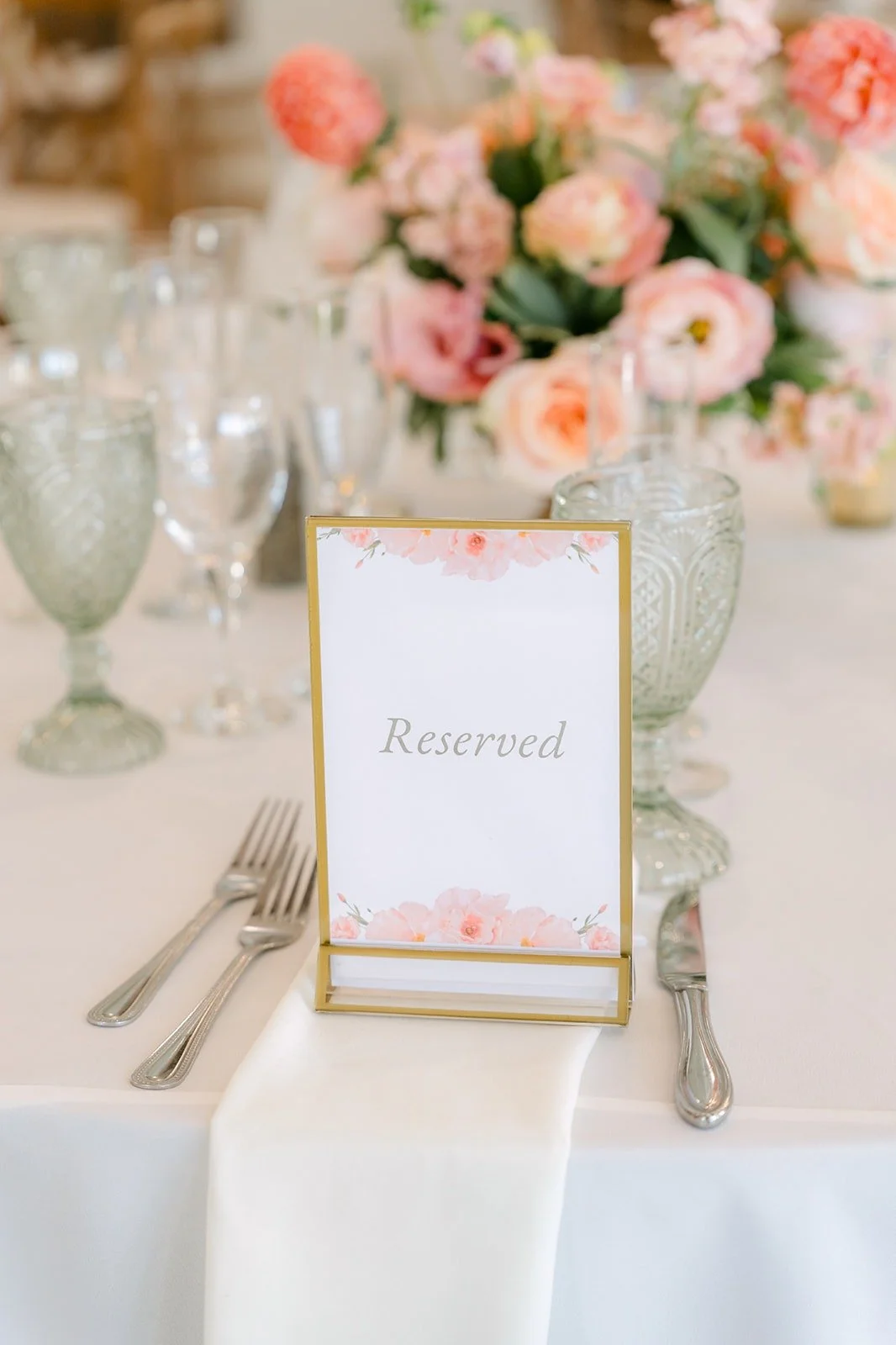 A place setting with a framed card and pink florals