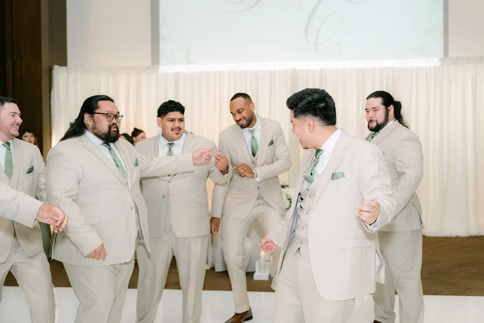 The groomsmen dancing in a line.