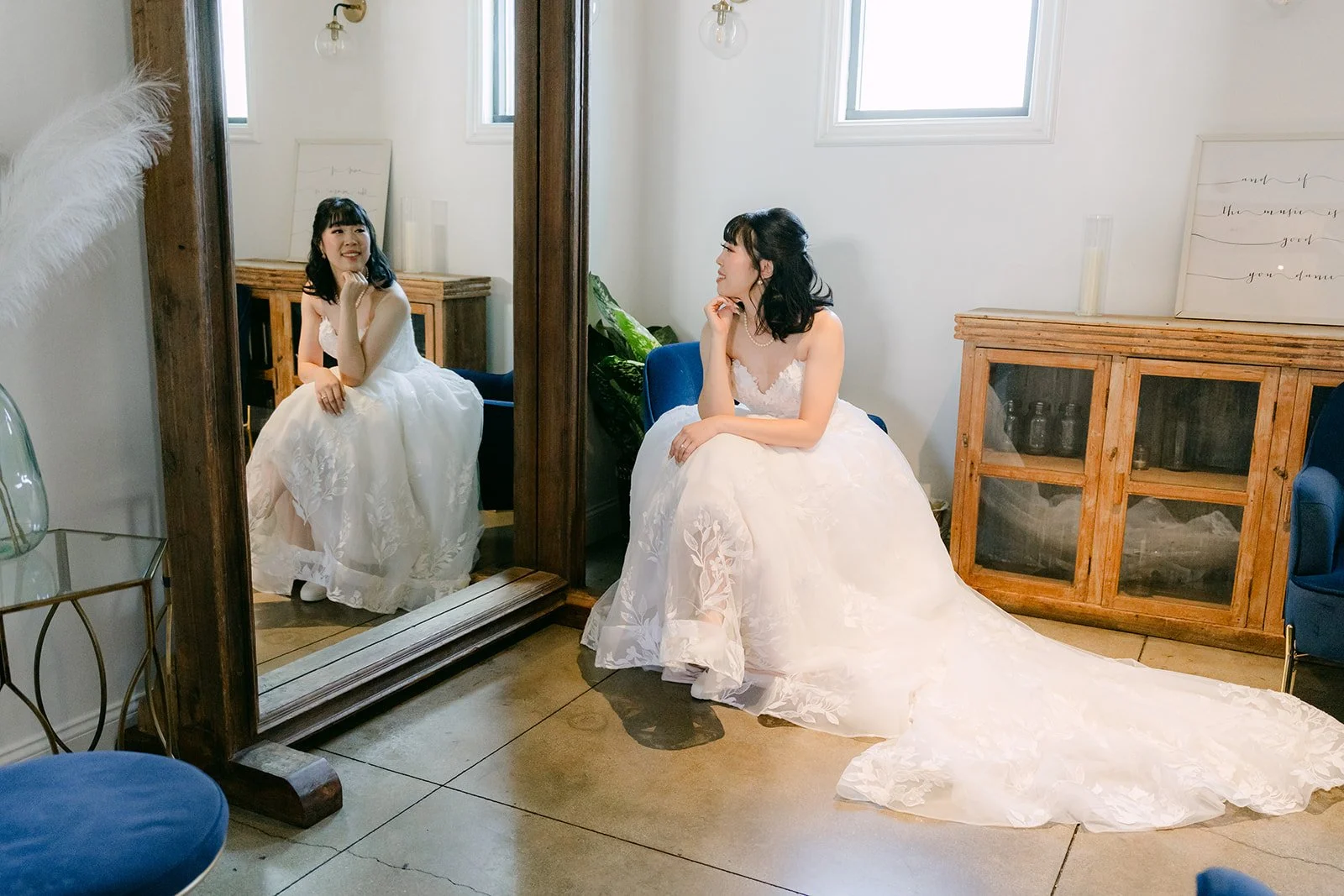Vivian seated with her gown spread out beside a vintage mirror