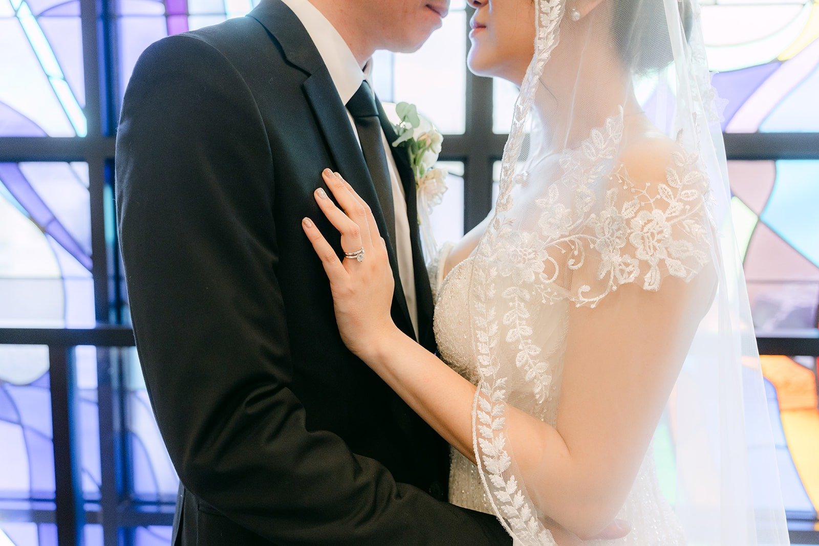Eunice rests her hand on Eric's chest beside the stained glass