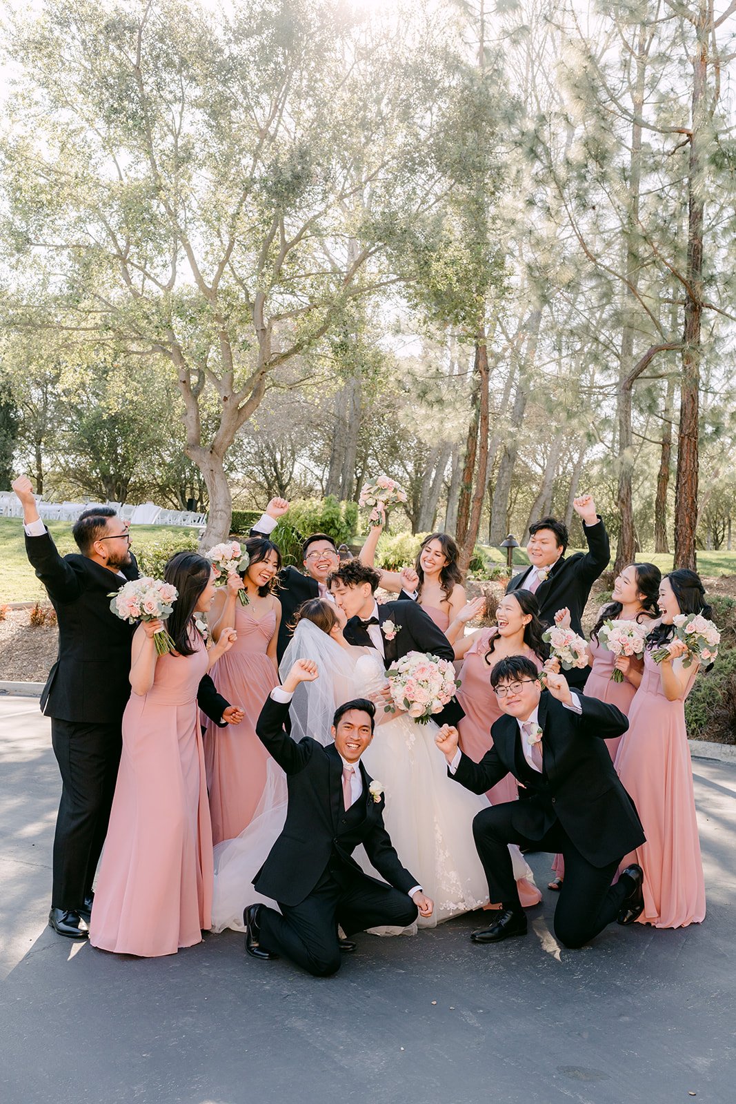 Wedding party cheering around the newlyweds
