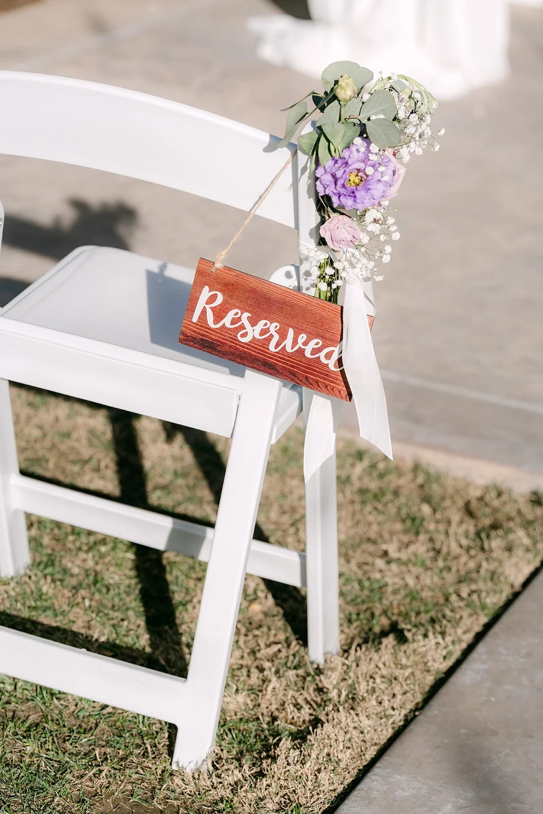 A reserved sign and florals on a ceremony chair.