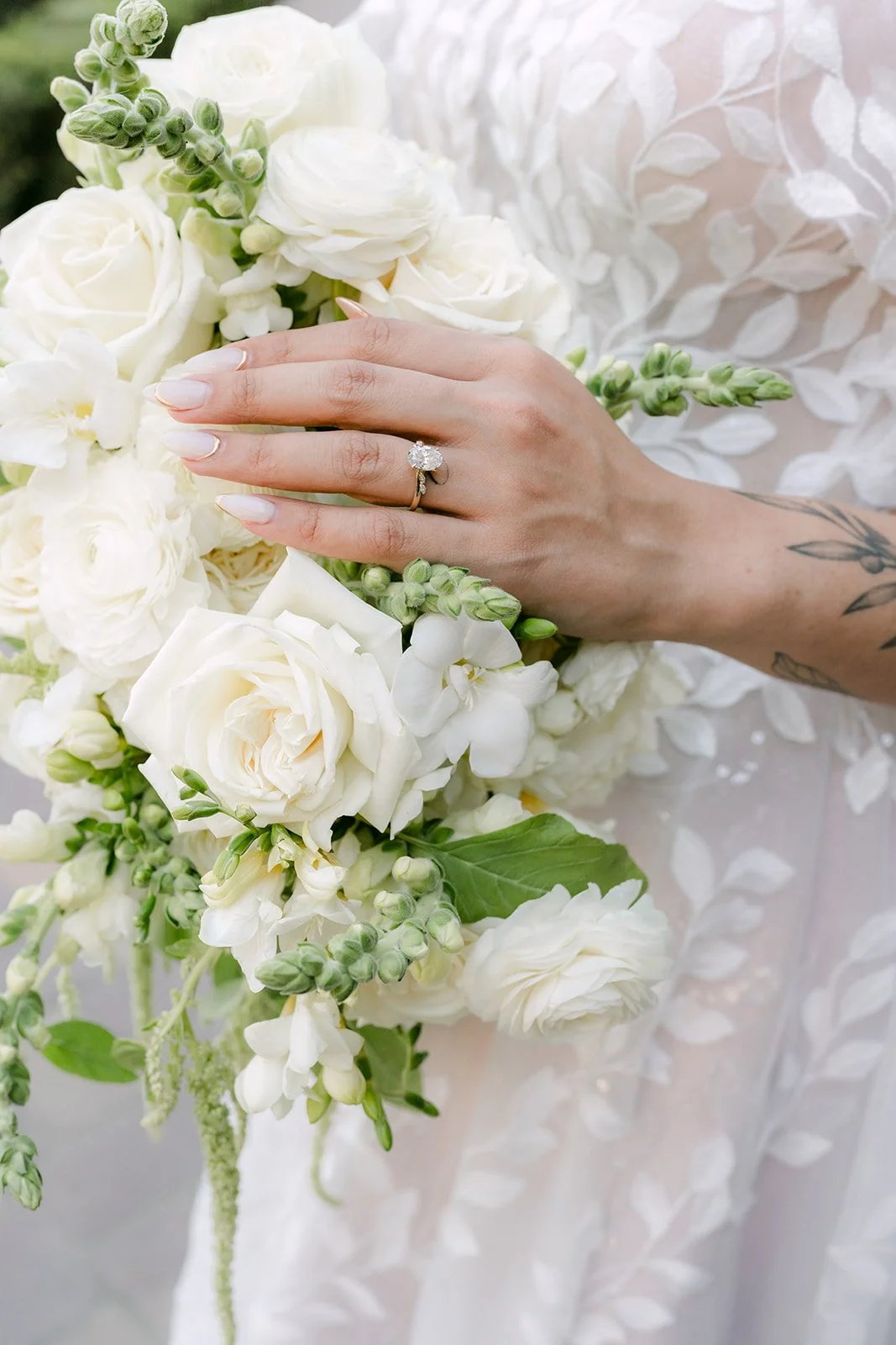 Close detail of Fernanda's white bouquet and lace sleeve.