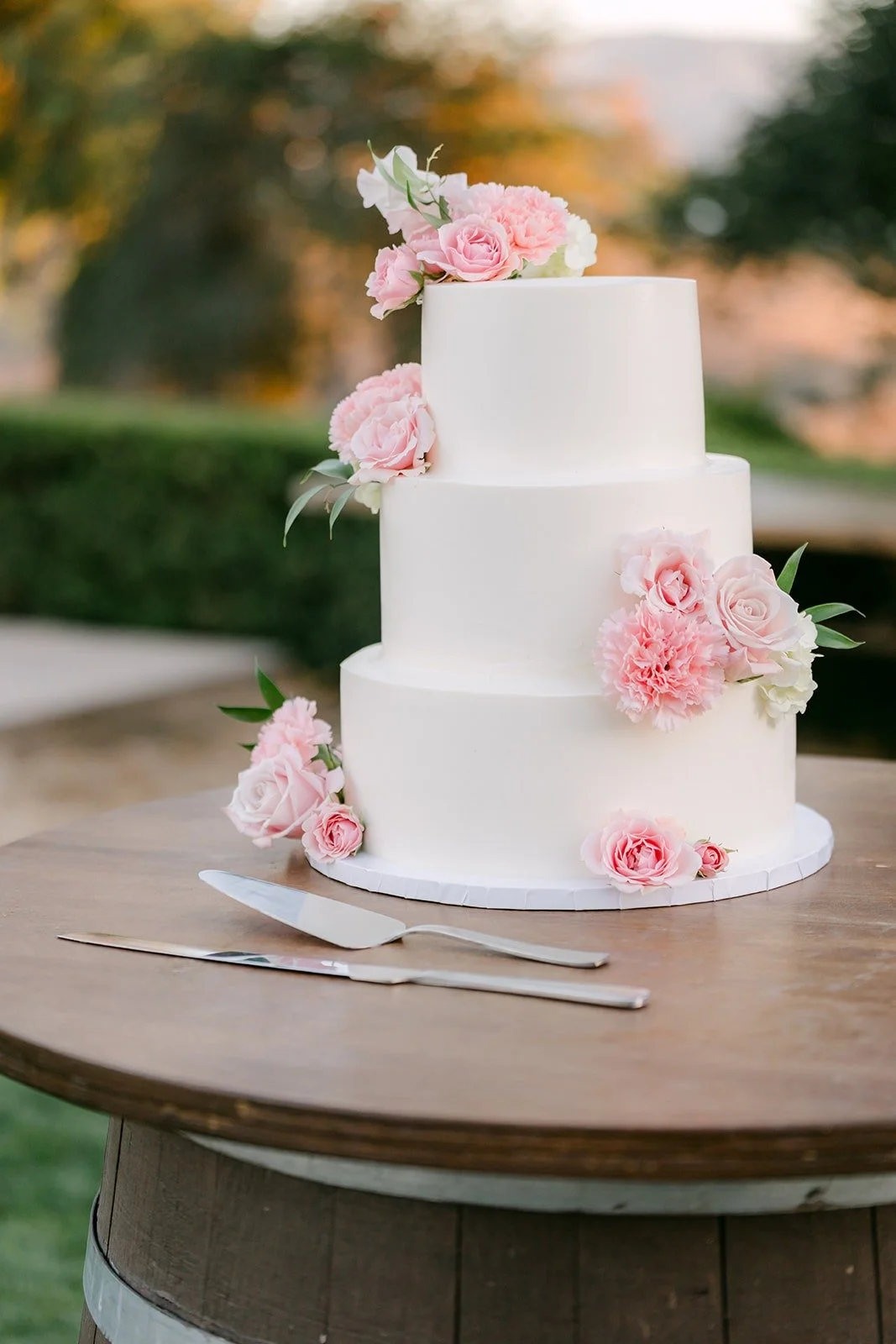 Three tier white cake with pink roses from 1914 Bakery