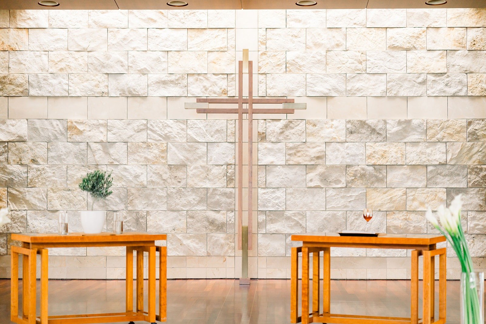 A wooden cross on the stone wall behind the altar